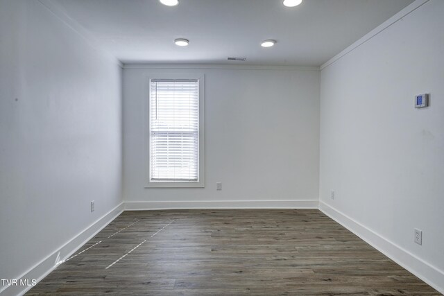 unfurnished room featuring recessed lighting, visible vents, dark wood-type flooring, ornamental molding, and baseboards