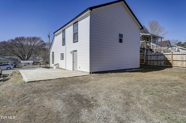 view of home's exterior with fence and a patio