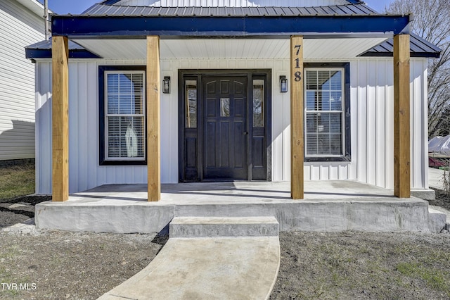 entrance to property with a porch, metal roof, and board and batten siding