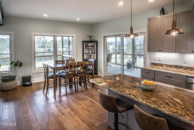 kitchen with recessed lighting, gray cabinets, dark wood-type flooring, dark stone countertops, and baseboards