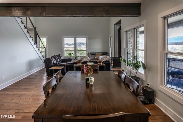 dining space featuring dark wood finished floors, baseboards, and stairs