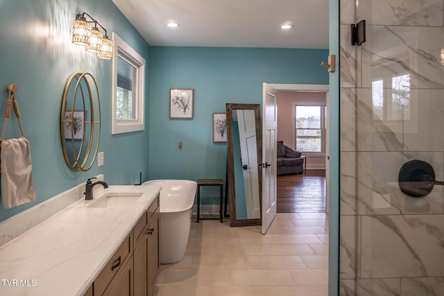 full bath featuring a shower with door, recessed lighting, a freestanding bath, and vanity