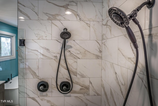 interior details with a tile shower and vanity