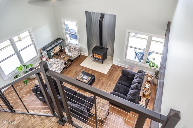 living room featuring a wood stove, baseboards, and wood finished floors