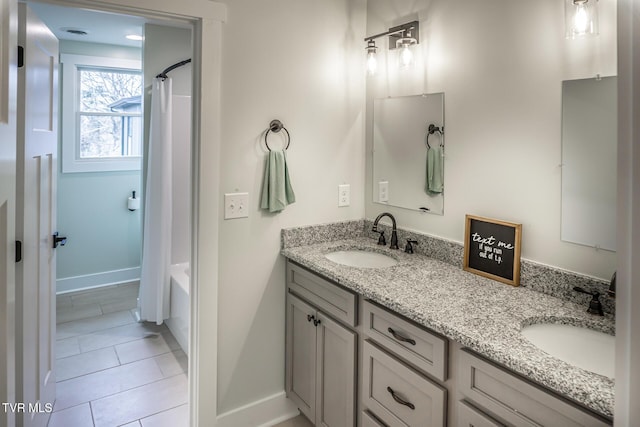 full bath with double vanity, shower / bath combination with curtain, a sink, and tile patterned floors