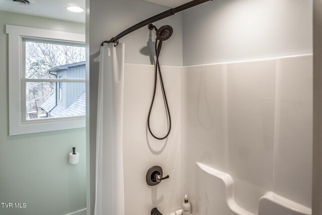 bathroom featuring shower / bath combination with curtain and visible vents