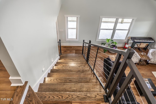 staircase featuring baseboards and wood finished floors