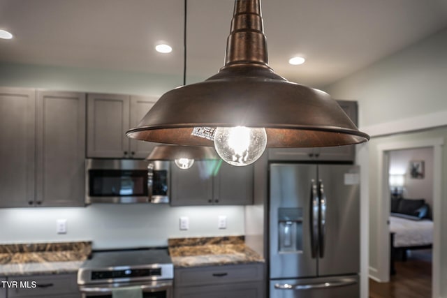 kitchen featuring dark stone counters, appliances with stainless steel finishes, gray cabinets, and recessed lighting