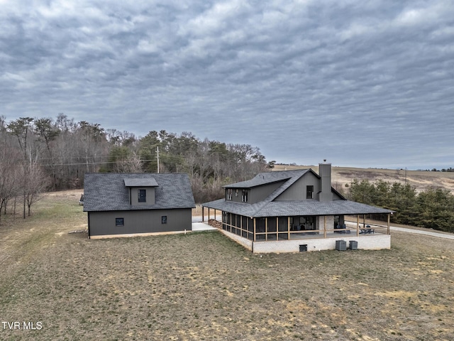 back of house with a sunroom and an outdoor structure