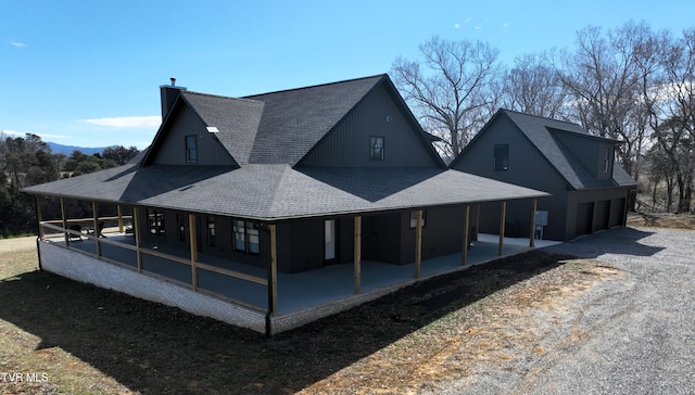 back of property featuring a patio area, a chimney, and roof with shingles