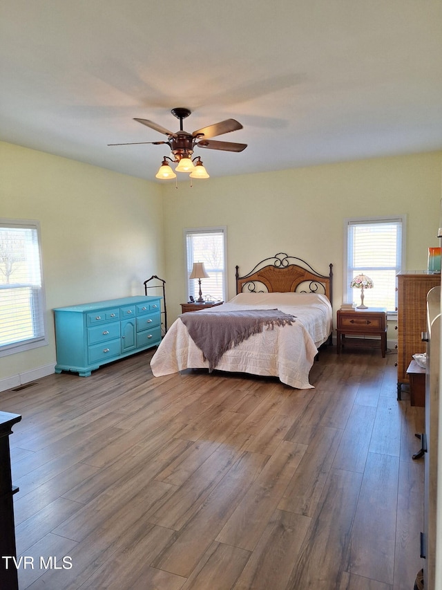 bedroom with ceiling fan, dark wood-type flooring, and visible vents