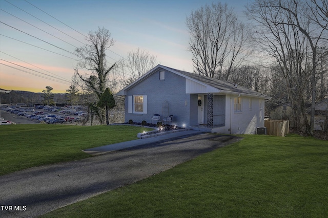 view of front of property featuring a front yard, brick siding, and cooling unit