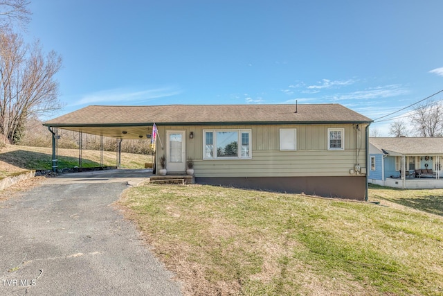 view of front of property featuring driveway, a carport, and a front yard