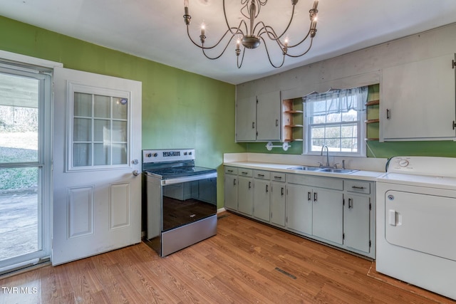 kitchen with electric stove, open shelves, light wood-style floors, a sink, and washer / dryer