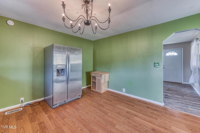 kitchen featuring visible vents, stainless steel refrigerator with ice dispenser, wood finished floors, and a chandelier