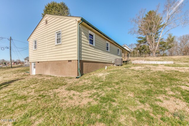 view of side of home featuring a yard and central AC unit