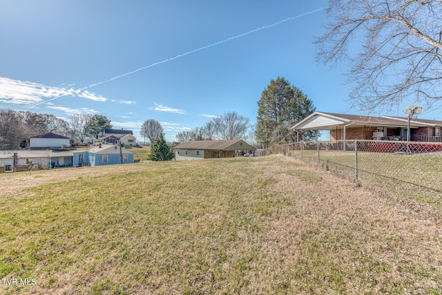 view of yard with a carport and fence