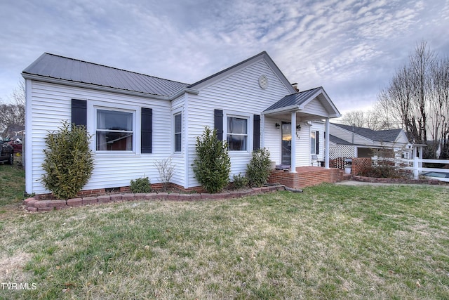 view of front of property with metal roof, crawl space, and a front yard