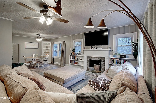 living area with a healthy amount of sunlight, a fireplace, a textured ceiling, and wood finished floors