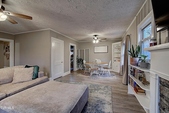 living area featuring ceiling fan, crown molding, a textured ceiling, and wood finished floors