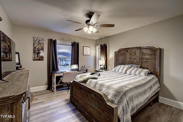 bedroom with light wood-style flooring, baseboards, and ceiling fan