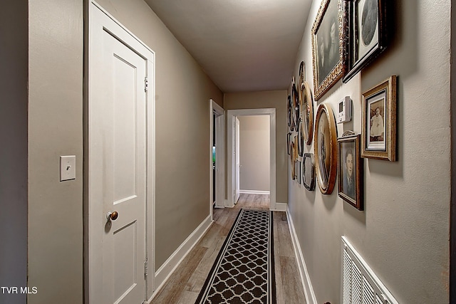 hall featuring baseboards and wood finished floors