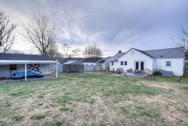 view of yard featuring french doors, a patio area, and a fenced backyard