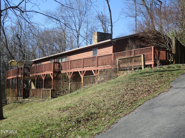 exterior space with a chimney and a wooden deck