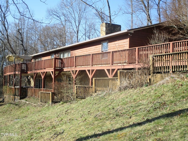 rear view of property with a chimney and a wooden deck