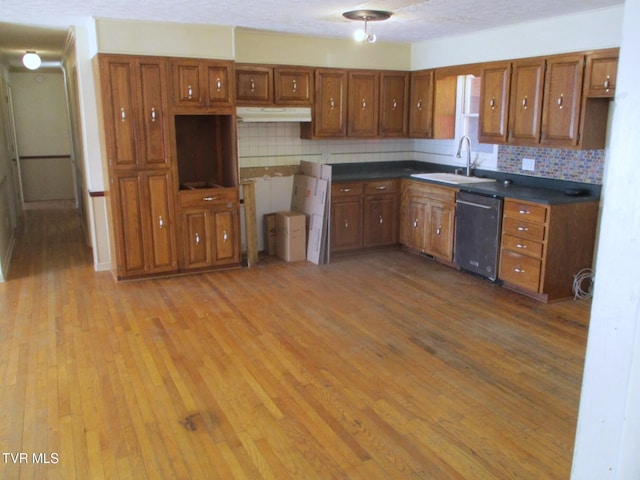 kitchen featuring a sink, brown cabinets, and dishwasher