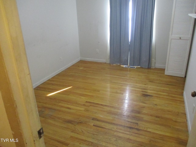 spare room with light wood-style flooring and baseboards