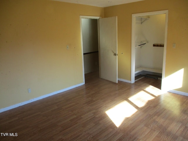 unfurnished bedroom with a closet, baseboards, and wood finished floors