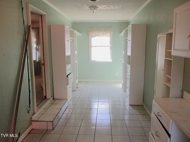 bathroom featuring ornamental molding, tile patterned flooring, a textured ceiling, and baseboards