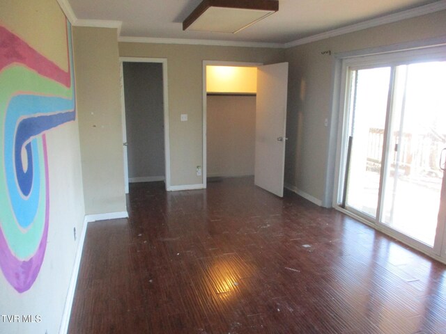 empty room featuring plenty of natural light, dark wood finished floors, and crown molding