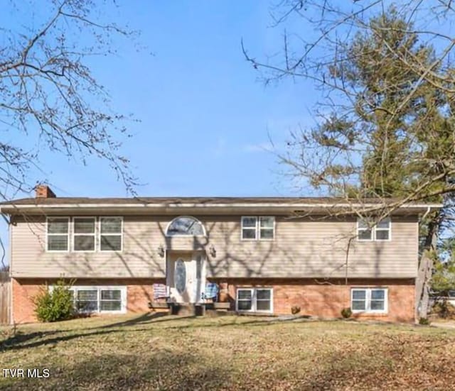 split foyer home featuring a front yard and a chimney