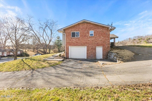 view of home's exterior with a garage, brick siding, and central AC unit