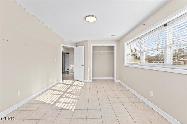 unfurnished bedroom with a closet, baseboards, and light tile patterned floors