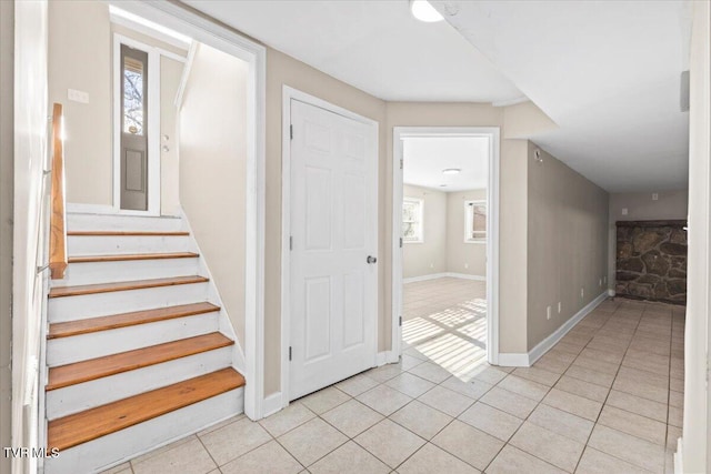 stairs with baseboards and tile patterned floors