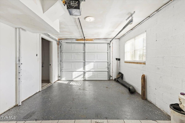 garage with concrete block wall and a garage door opener