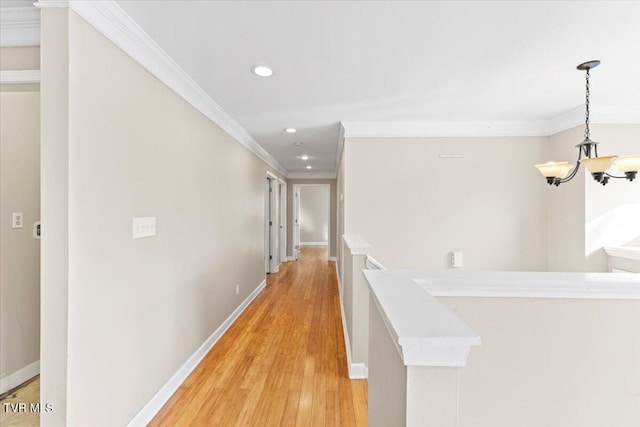 corridor with light wood-style floors, baseboards, ornamental molding, and recessed lighting