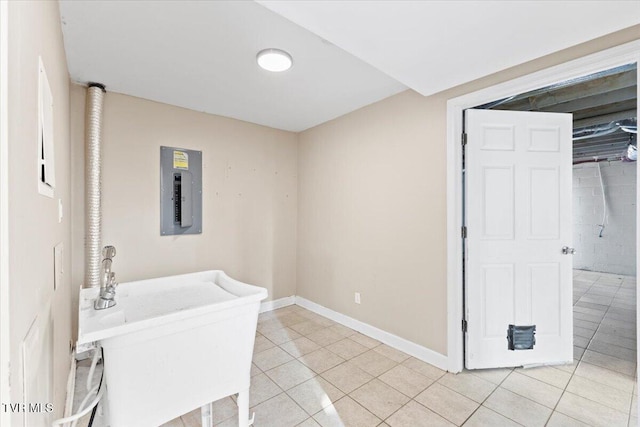 interior space with tile patterned flooring, electric panel, baseboards, and a sink