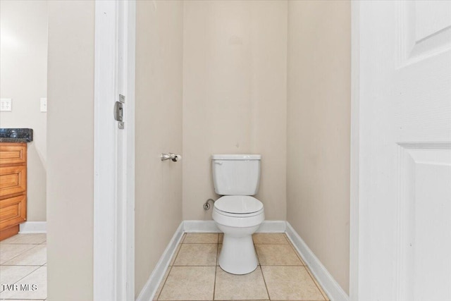 bathroom featuring toilet, baseboards, and tile patterned floors