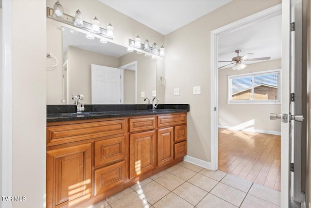 full bath featuring tile patterned flooring, a sink, baseboards, and double vanity