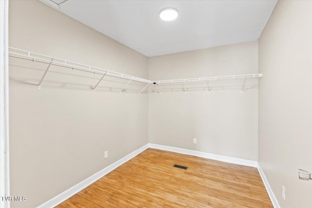 walk in closet featuring wood finished floors and visible vents