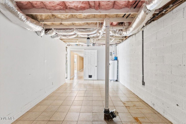 unfinished basement with gas water heater and light tile patterned floors