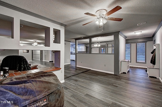 living area with a textured ceiling, wood finished floors, visible vents, and ornamental molding