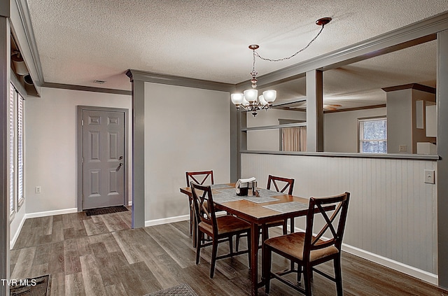 dining room featuring visible vents, ornamental molding, dark wood-type flooring, a textured ceiling, and a chandelier