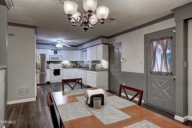 dining space with visible vents, crown molding, ceiling fan with notable chandelier, a textured ceiling, and dark wood-style flooring