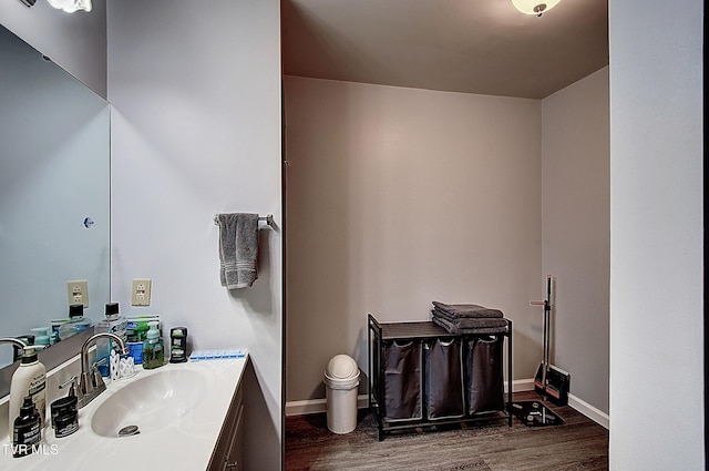 bathroom featuring vanity, baseboards, and wood finished floors