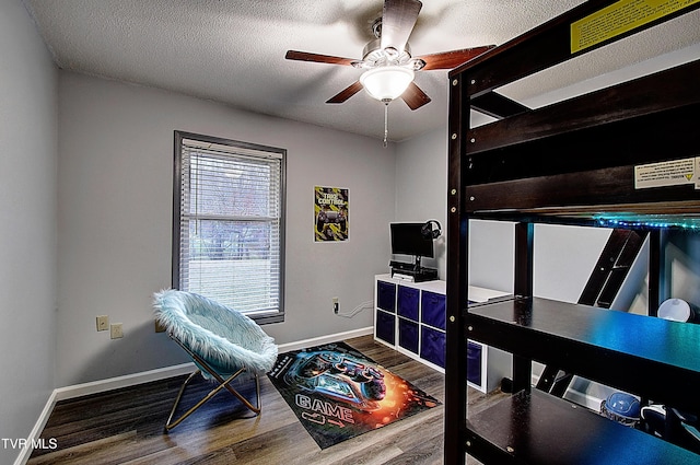 bedroom with ceiling fan, a textured ceiling, baseboards, and wood finished floors